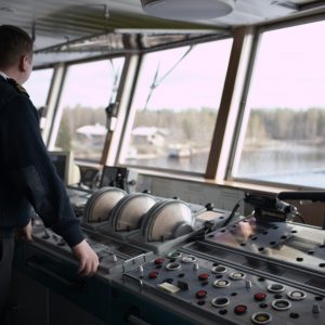 Navigation officer driving cruise liner on the river.
